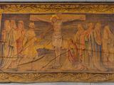 an old tapestry hanging on a wall with a crucif
