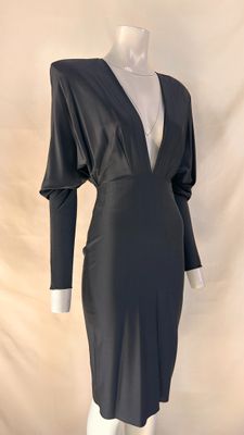 the dress is black and has a v - neck and long sleeves