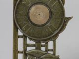 une horloge en bronze posée sur un socle orné d'une feuille
