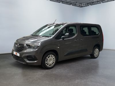 La camionnette grise est garée dans une grande pièce aux murs blancs.