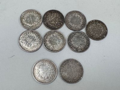 six types différents de pièces d'argent sur une surface blanche