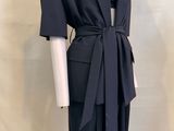 the mannequin is wearing a black suit with a tie around the waist