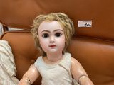 a doll that is sitting on a chair in the room