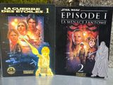 « Star Wars : Épisode I » et « Star Wars : Épisode II » sont exposés devant un mur de pierre