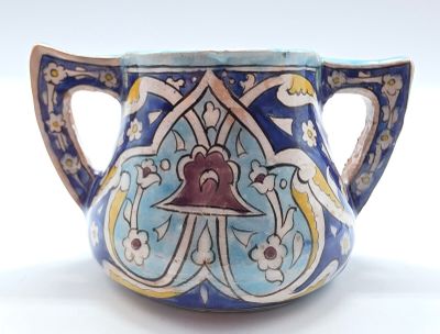 un vase bleu et jaune orné d'une clochette