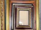 two frames with a gold border and a black one with a gold border