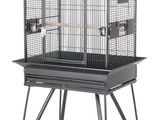 une grande cage à oiseaux noire, munie de roulettes et d'une poignée en bois
