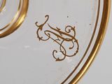 a glass vase with a gold rim and a monogram on it