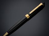 a black and gold ballpoint pen on a black background