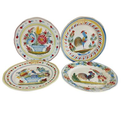 quatre assiettes de couleurs différentes, ornées de coqs et de fleurs