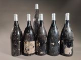 six bottles of wine are lined up in a row on a table