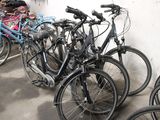 many bikes that are lined up against a wall