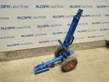 an image of a blue hand truck parked in front of a wall