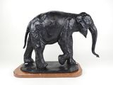 statue d'un éléphant debout sur un socle en bois, sur fond blanc