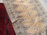 two rugs on the floor next to a suitcase