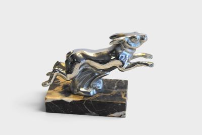 statue of a dog leaping over a marble block