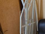 un ventilateur posé à côté d'une chaise dans un coin de la pièce