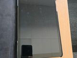 une tablette posée sur un bureau, à côté d'un portefeuille