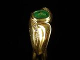 an image of a gold ring with a green stone in the center