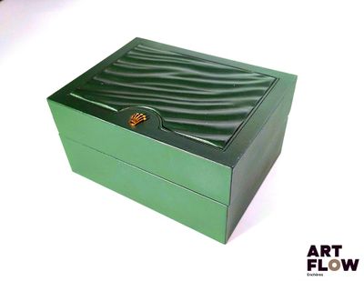 une boîte verte posée sur une surface blanche