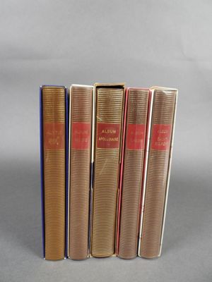 quatre livres sont alignés sur une surface grise
