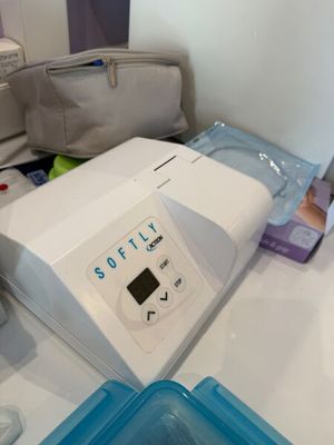 une machine blanche posée sur un comptoir, à côté d'un récipient bleu