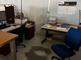 un bureau avec un ordinateur et une chaise dans une pièce