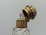 a small glass bottle with a gold lid and a gold cap