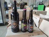 three bottles of beer sitting on a box in a warehouse