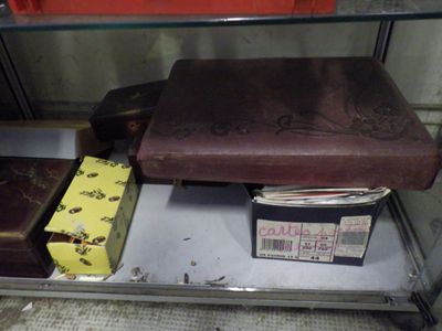 several suitcases and boxes are on a shelf in a room