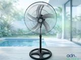 un ventilateur noir posé sur une table près d'une piscine