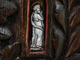 carvings of a statue of a woman holding a child in a wooden frame