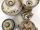 quatre pièces de poterie différentes posées sur une surface blanche