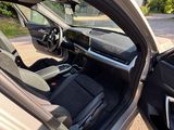 the interior of a car with the door open and the driver ' s seat down