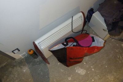 un sac posé par terre à côté d'un radiateur