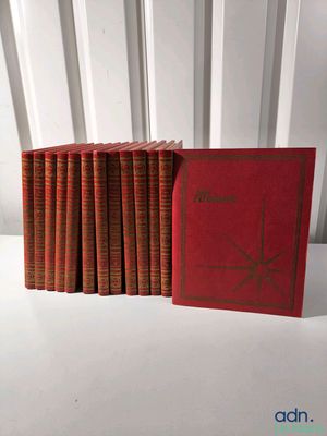 plusieurs livres rouges empilés les uns sur les autres sur une table blanche