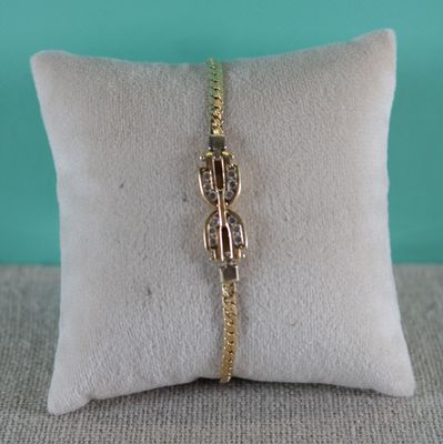 un gros plan sur un coussin sur lequel repose un bracelet en or