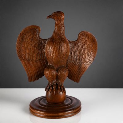 une photo d'une sculpture en bois représentant un oiseau sur un socle