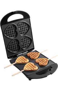 a close up of a waffle maker with four heart shaped waffles