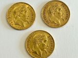 three gold sovereigns, one of which has a head of a man and two of which have a woman on them