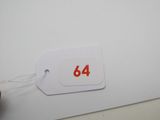 une étiquette portant le numéro 64, fixée sur un morceau de papier