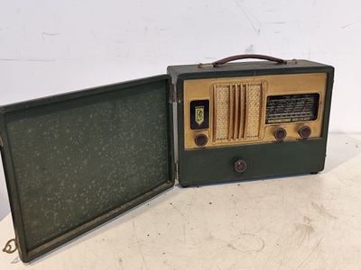 une radio à l'ancienne posée sur une table, à côté d'une valise