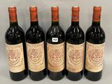 six bottles of wine are lined up in a row