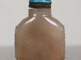 a small glass bottle with a lid on a table