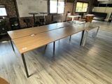 des tables et des chaises dans une pièce où se trouve un tableau blanc accroché au mur