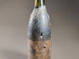 an old bottle of wine is sitting on a table