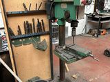 a machine that is sitting in a garage with tools on it
