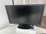 a computer monitor sitting on top of a white table next to a keyboard