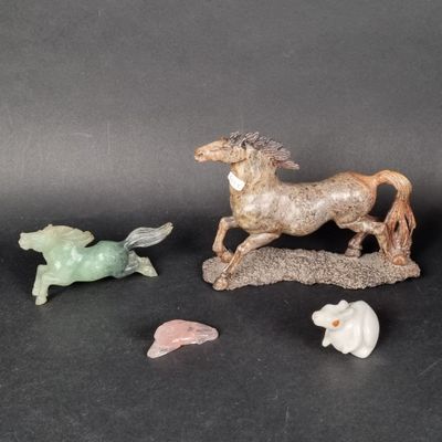 three figurines of horses and a fish on a black surface