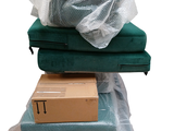 a pile of boxes and a bag on top of a couch